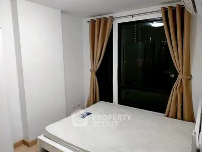 Cozy bedroom with large window and elegant curtains, perfect for restful nights.