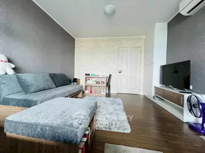 Modern living room with stylish furniture and cozy ambiance, featuring a plush sofa and sleek TV setup.