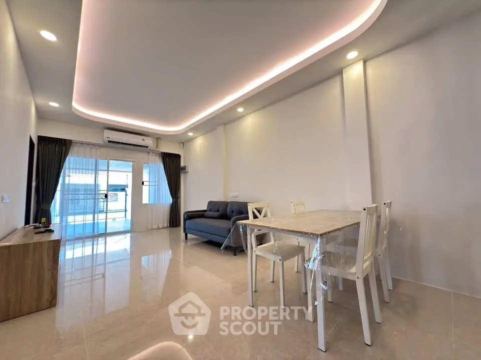 Spacious modern living room with elegant lighting and sleek furniture, perfect for comfortable living.