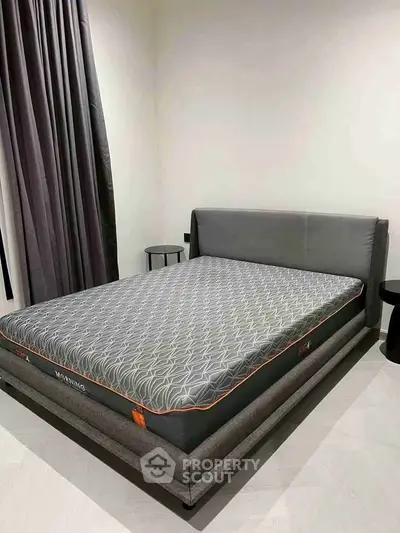 Modern bedroom with stylish bed and elegant curtains in a cozy setting.