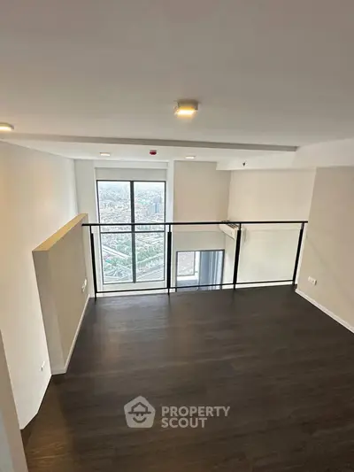 Modern loft-style living room with large windows and sleek flooring.