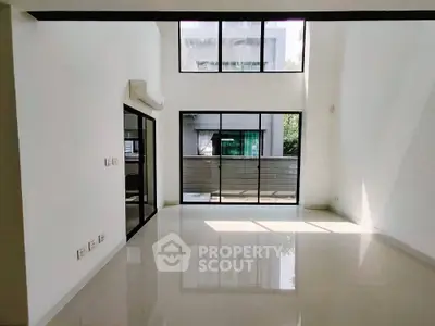 Spacious modern living room with large windows and high ceiling
