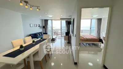 Modern open-plan living and dining area with a view of the balcony and bedroom.