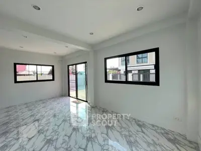 Spacious modern living room with marble flooring and large windows in a bright, open layout.