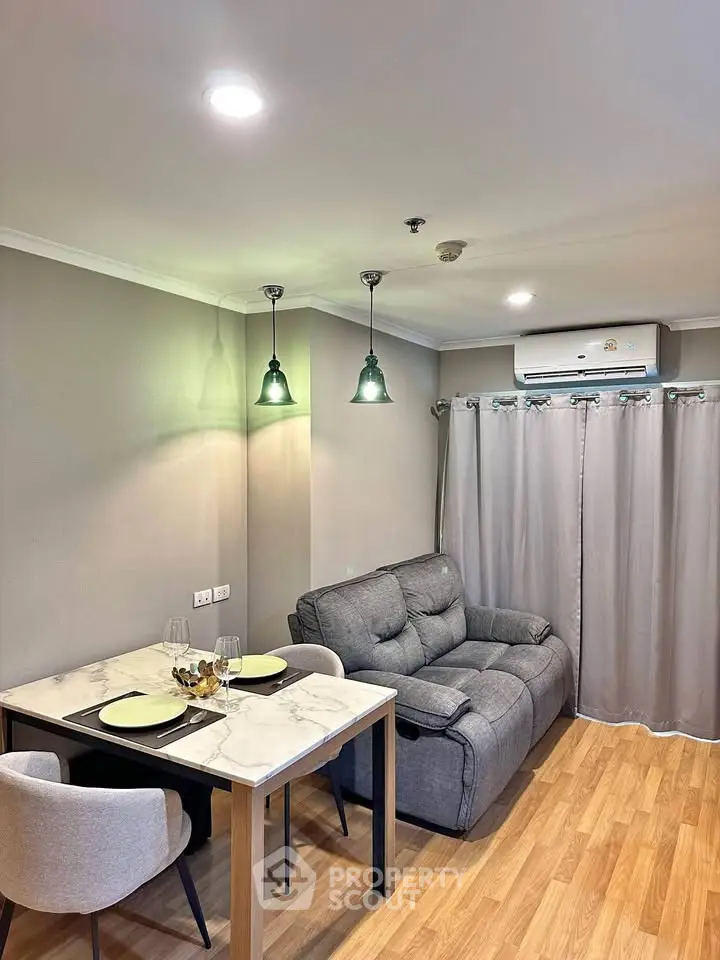 Cozy living room with modern decor, featuring a plush sofa, dining table, and ambient lighting.