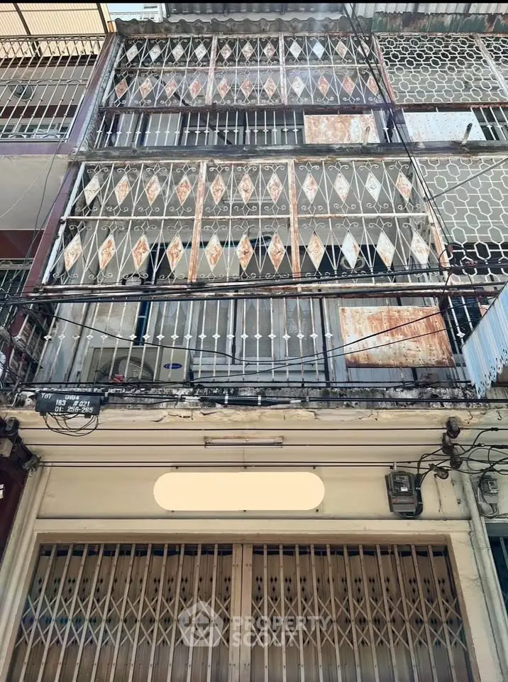 Charming multi-story building with unique balcony railings and rustic facade, perfect for urban living.
