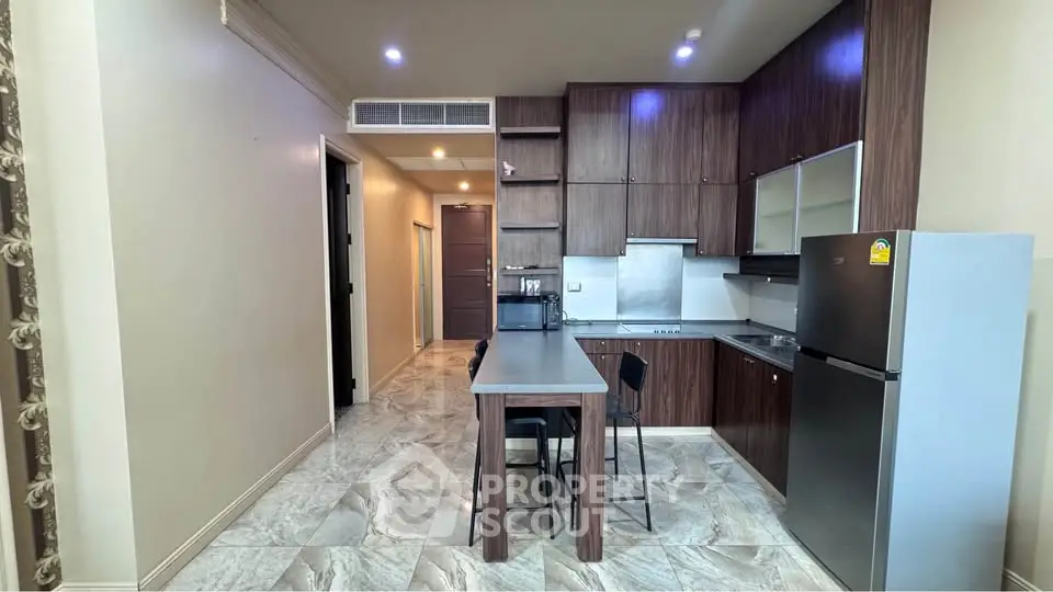 Modern kitchen with sleek cabinetry and stainless steel appliances in a stylish apartment.