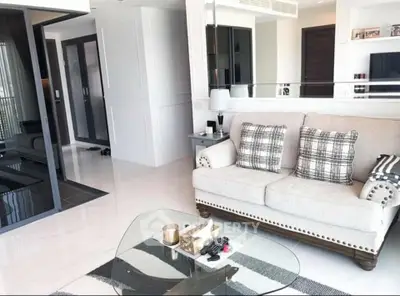 Modern living room with elegant sofa and glass coffee table in a bright, stylish apartment.
