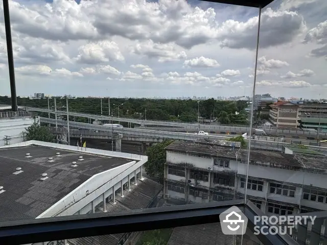 Stunning cityscape view from high-rise building window showcasing urban skyline and lush greenery.