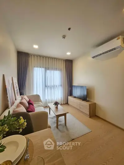 Modern living room with cozy sofa, TV, and elegant decor in a bright apartment.