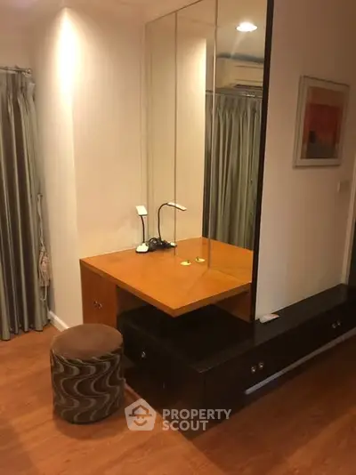 Cozy bedroom corner with wooden vanity and stylish stool