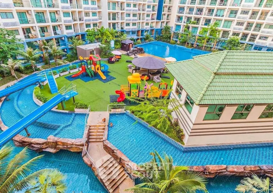 Luxurious condo with pool, playground, and lush landscaping for family-friendly living.