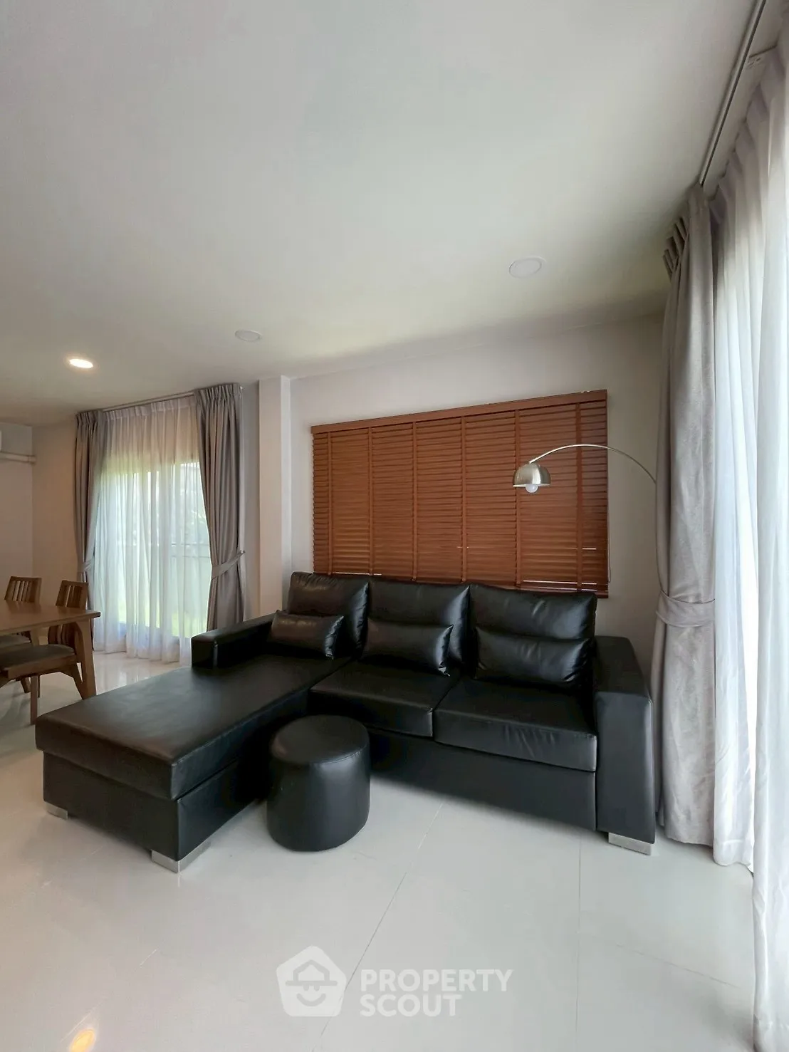 Spacious living room with modern black leather sofa and elegant decor