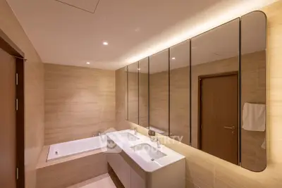 Luxurious modern bathroom with dual sinks and bathtub in elegant beige tones.