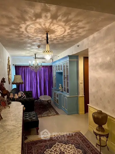 Elegant living room with vintage decor, ornate chandeliers, and luxurious purple curtains.