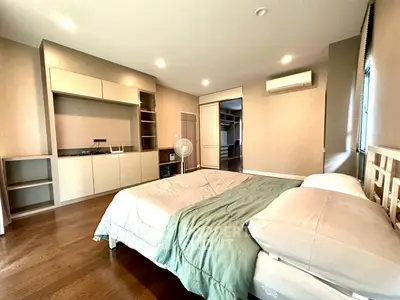 Spacious modern bedroom with built-in storage and hardwood floors