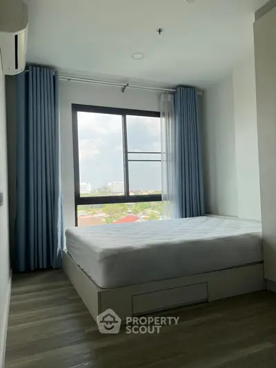 Bright bedroom with large window and modern decor in a stylish apartment.
