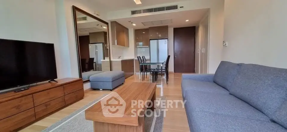 Spacious modern living room with wooden furniture and open kitchen layout.