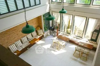 Spacious living room with high ceilings and large windows offering abundant natural light.