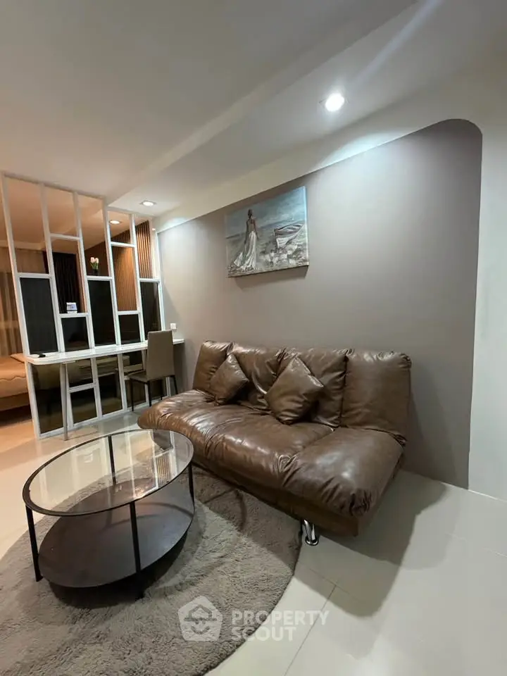 Modern living room with brown leather sofa and stylish decor in a cozy apartment.