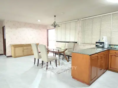 Spacious dining area with elegant furniture and floral wallpaper, perfect for family gatherings.