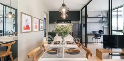 Modern open-plan dining area with stylish kitchen and cozy study nook, featuring elegant decor and natural light.