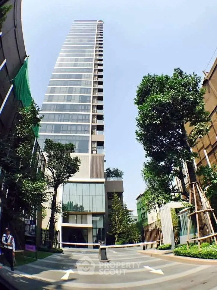 Modern high-rise building with sleek architecture and lush greenery in urban setting