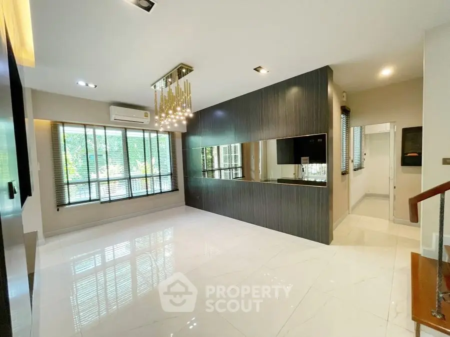 Spacious modern living room with elegant chandelier and large windows