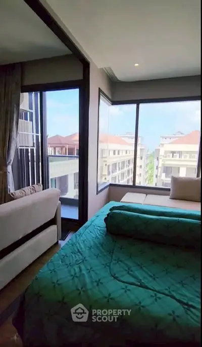 Luxurious bedroom with stunning city view and cozy seating area.