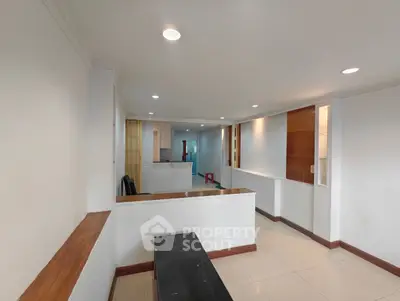 Spacious open-plan living area with modern lighting and sleek design.