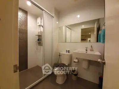 Modern bathroom with shower and sleek fixtures in contemporary apartment.