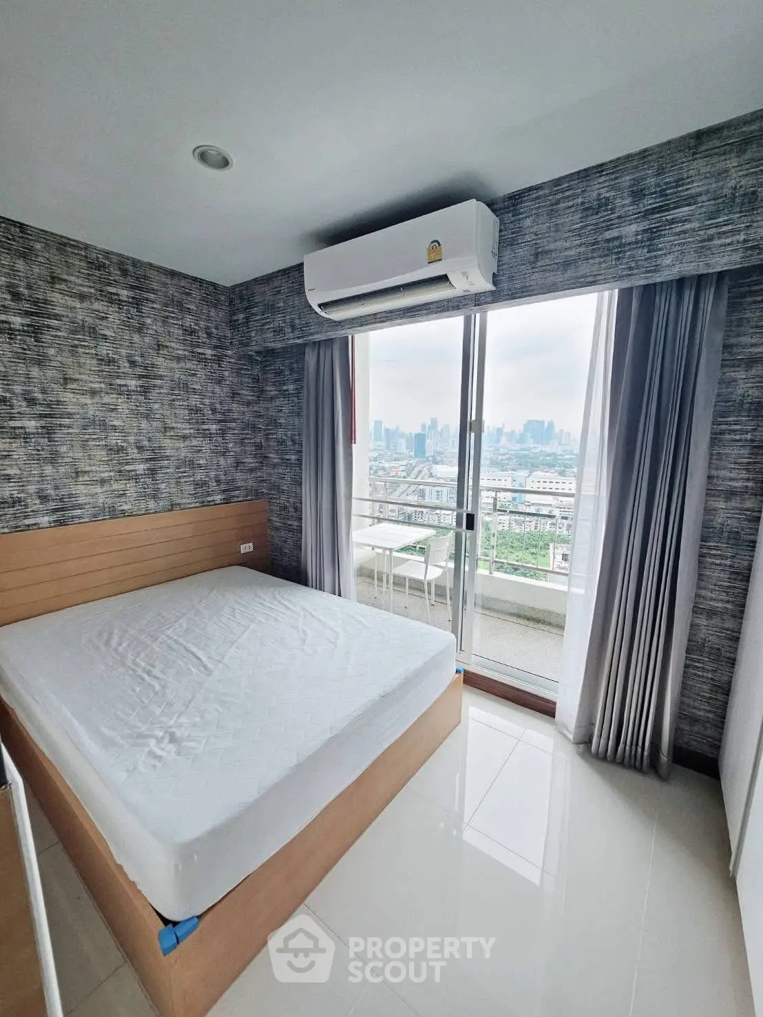 Modern bedroom with balcony and city view, featuring air conditioning and stylish decor.
