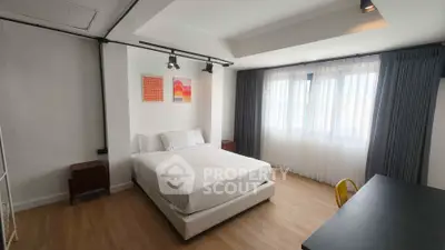 Modern bedroom with stylish decor and large windows for natural light