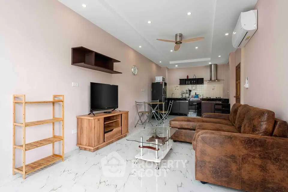 Modern living room with open kitchen, featuring stylish furniture and sleek design.