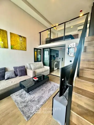 Modern loft-style living room with mezzanine, stylish decor, and cozy seating area.