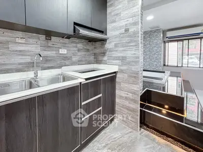 Modern kitchen with sleek cabinetry and stylish backsplash in a contemporary home.