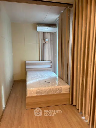 Cozy small bedroom with wooden flooring and air conditioning