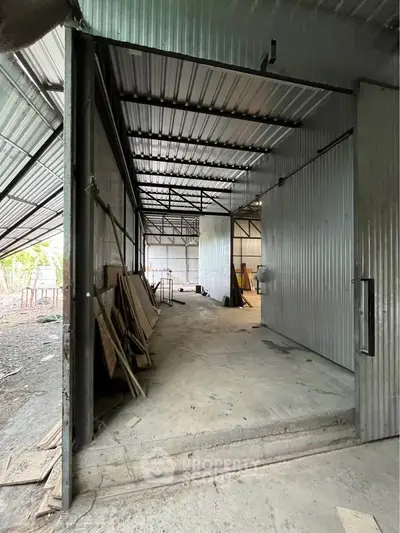 Spacious industrial warehouse with metal walls and open layout, ideal for storage or manufacturing.