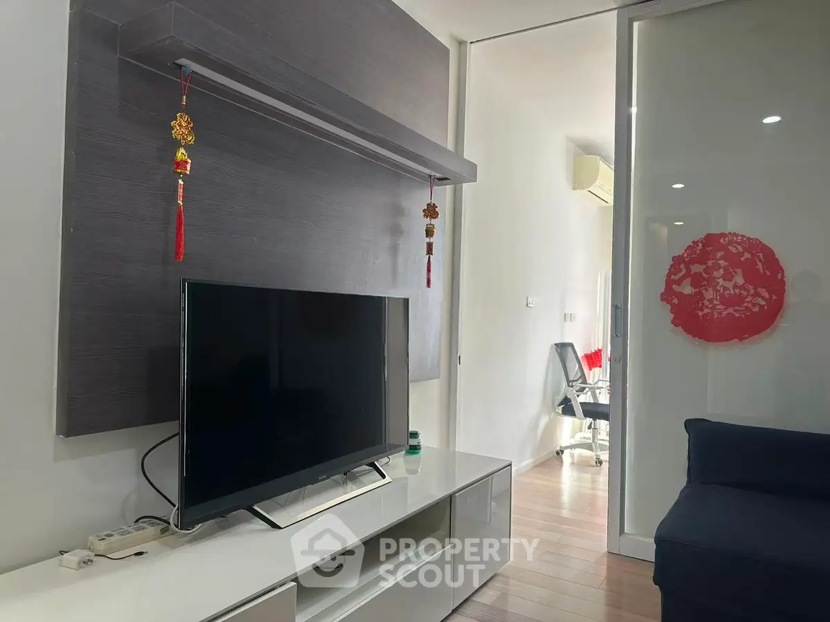 Modern living room with sleek TV setup and stylish decor in a contemporary apartment.