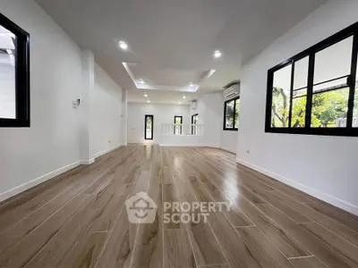 Spacious modern living room with wooden flooring and large windows