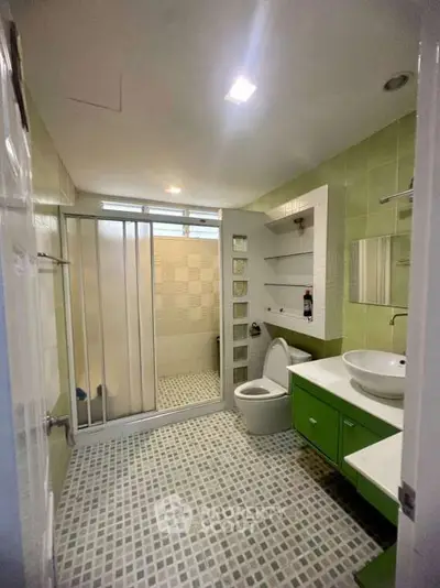 Modern bathroom with green accents and glass shower enclosure