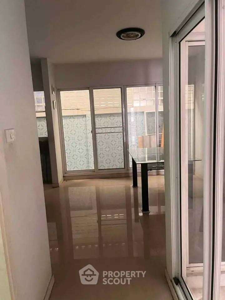 Spacious apartment interior with large windows and glossy floors, perfect for natural light lovers.
