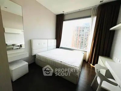 Modern bedroom with large window and city view, featuring sleek furniture and neutral tones.