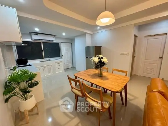 Modern kitchen and dining area with stylish furniture and bright lighting.