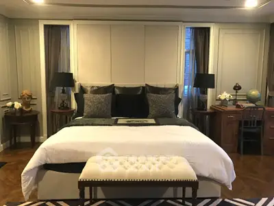 Luxurious bedroom with elegant decor and plush bedding in upscale home.
