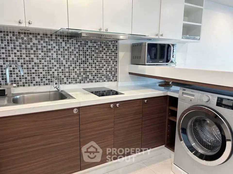 Modern kitchen with sleek cabinetry, built-in appliances, and stylish backsplash.