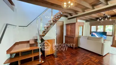 Charming living room with wooden staircase and cozy seating area, perfect for relaxation.