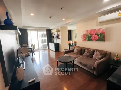 Spacious living room with modern decor and natural light, featuring a cozy sofa and elegant dining area.