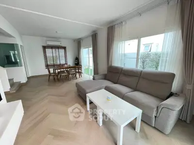 Spacious living room with modern furniture and large windows in a stylish home.