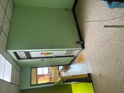 Spacious room with green walls and natural light, ideal for creative living space.